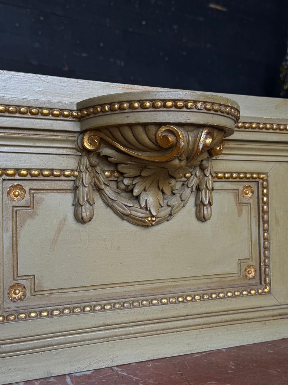 A matching pair of painted French neoclassical bedside cabinets featuring red marble tops, carved bracket superstructures, gold leaf detailing, drawers, and open lower shelves. View XV