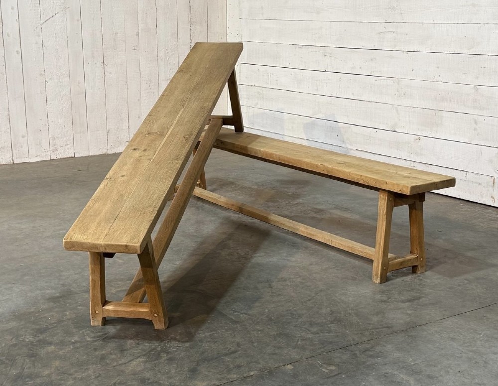 A pair of long rustic light oak dining benches with A-frame legs and cross-stretchers. View II