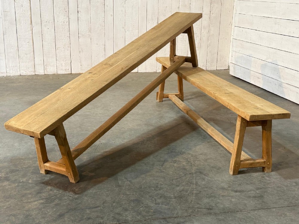 A pair of long rustic light oak dining benches with A-frame legs and cross-stretchers. View III