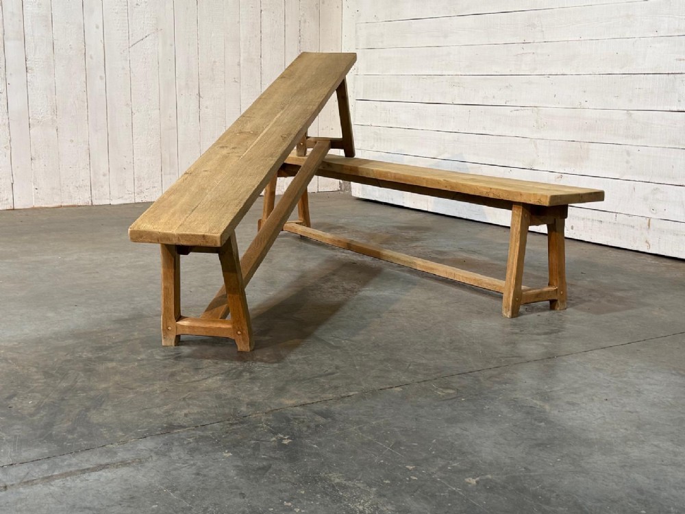 A pair of long rustic light oak dining benches with A-frame legs and cross-stretchers. View IV