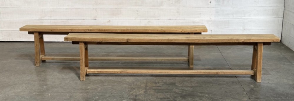 A pair of long rustic light oak dining benches with A-frame legs and cross-stretchers. View V