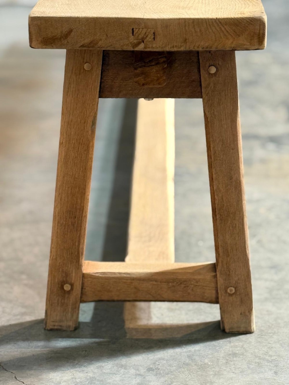 A pair of long rustic light oak dining benches with A-frame legs and cross-stretchers. View IX