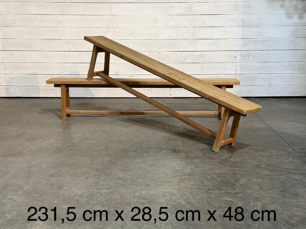 A pair of long rustic light oak dining benches with A-frame legs and cross-stretchers. View X