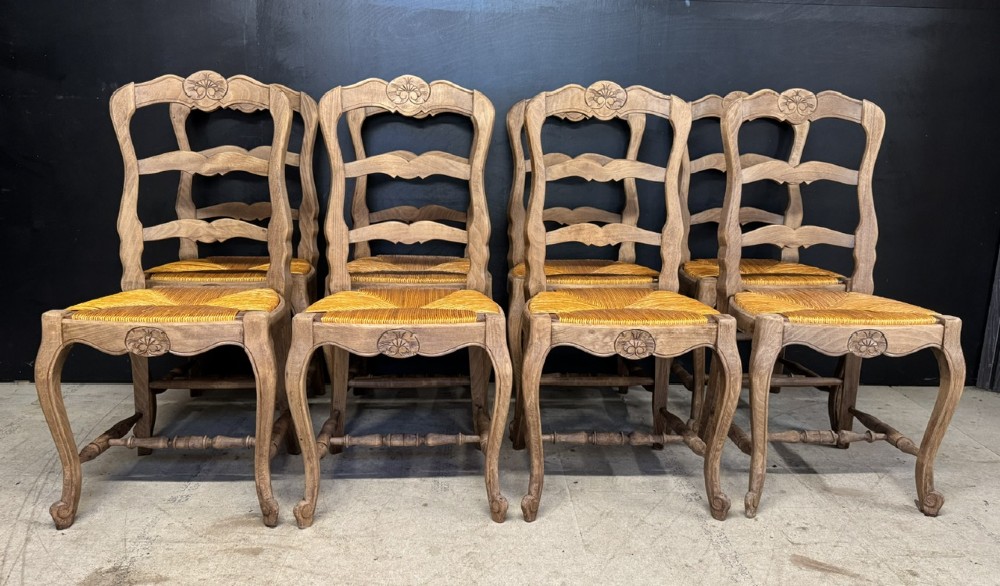 A set of eight French farmhouse dining chairs featuring carved wooden ladderback frames, woven rush seats, and cabriole front legs. View II