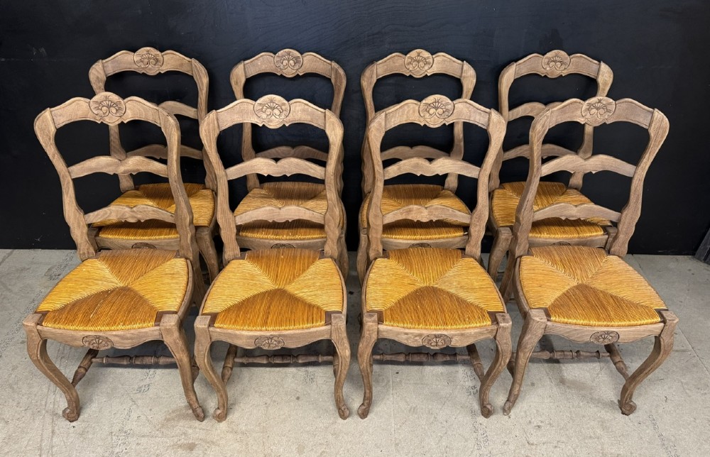 A set of eight French farmhouse dining chairs featuring carved wooden ladderback frames, woven rush seats, and cabriole front legs. View III