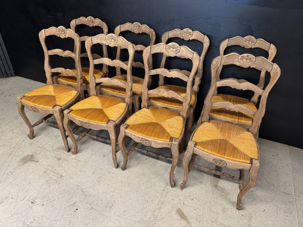 A set of eight French farmhouse dining chairs featuring carved wooden ladderback frames, woven rush seats, and cabriole front legs. View IV