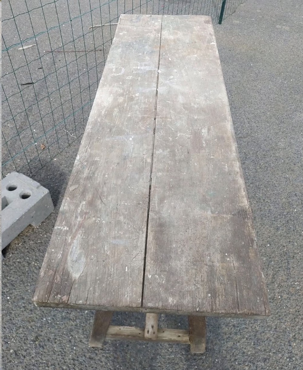 A rustic weathered wooden French laundry table featuring a plank top supported by angled A-frame trestle legs and a central stretcher. View IV
