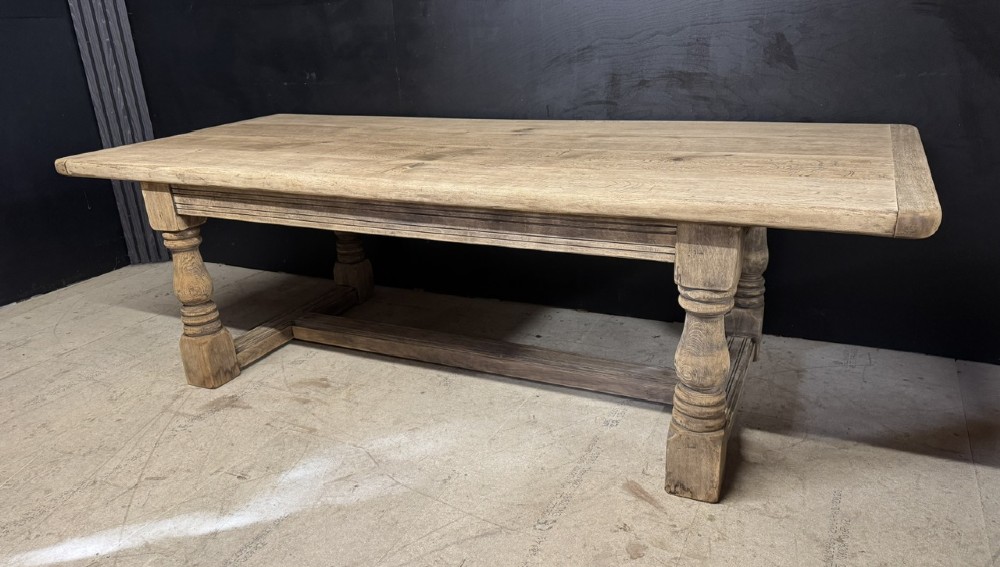 A large natural oak refectory dining table featuring turned legs, breadboard top ends, and an H-stretcher base. View II