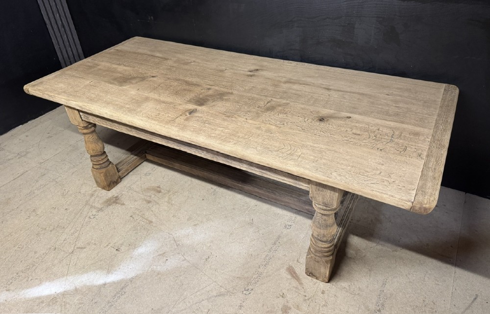 A large natural oak refectory dining table featuring turned legs, breadboard top ends, and an H-stretcher base. View III