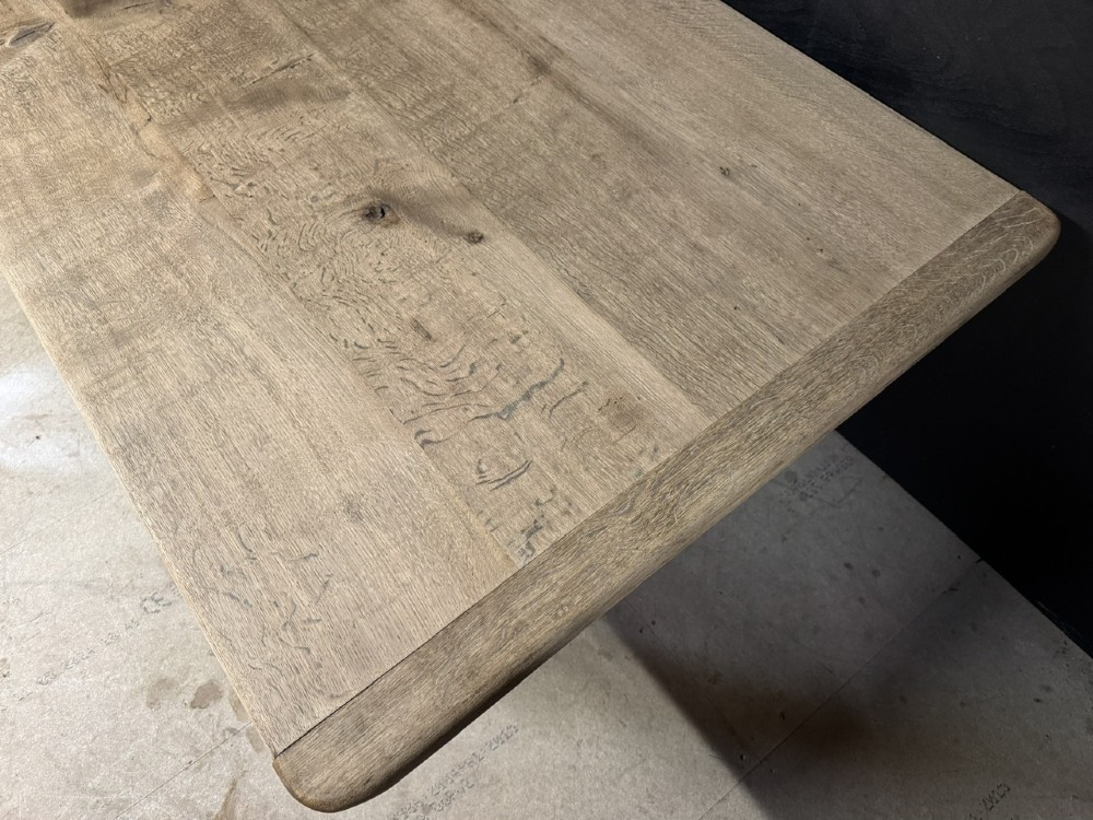 A large natural oak refectory dining table featuring turned legs, breadboard top ends, and an H-stretcher base. View VII