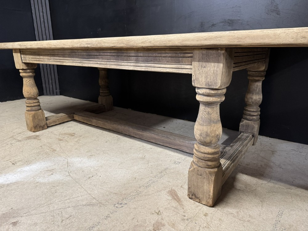 A large natural oak refectory dining table featuring turned legs, breadboard top ends, and an H-stretcher base. View X