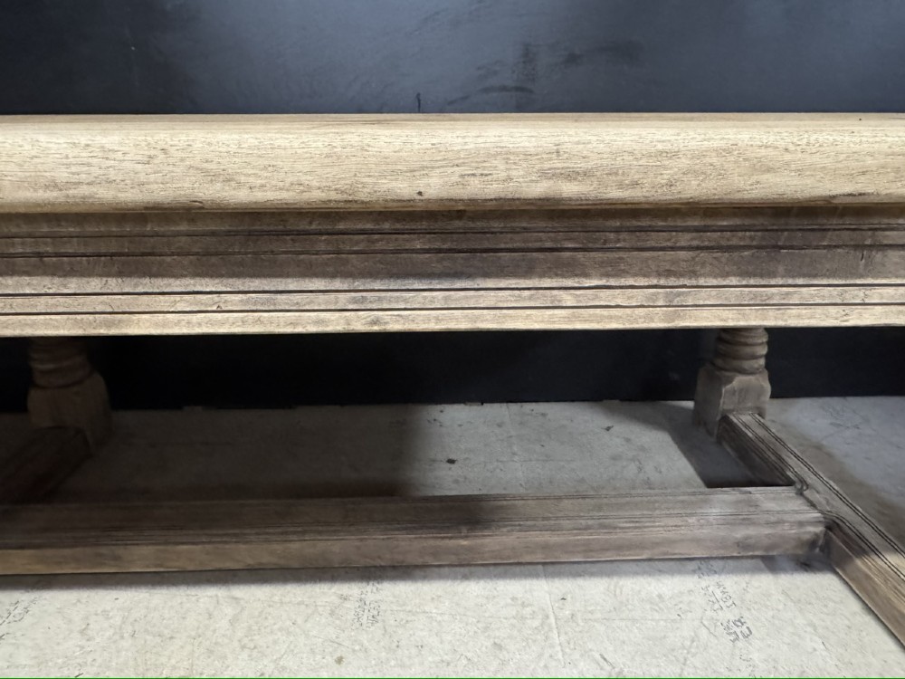 A large natural oak refectory dining table featuring turned legs, breadboard top ends, and an H-stretcher base. View XII
