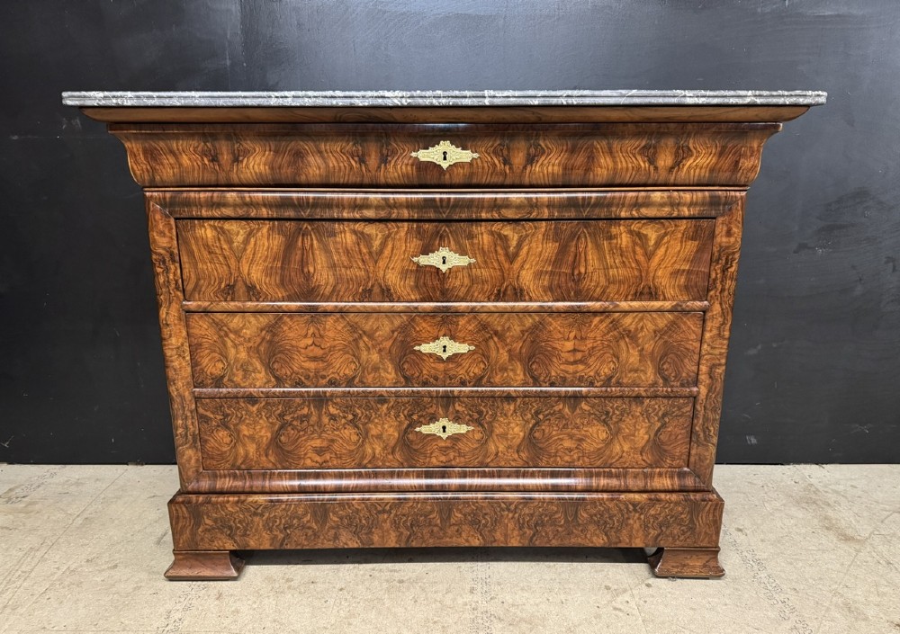 A 19th-century French Louis Philippe burr walnut commode featuring a grey marble top, four drawers, and ornate brass keyhole escutcheons. View III