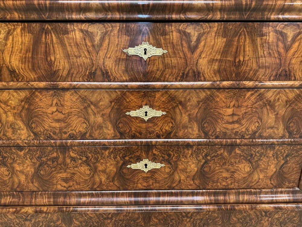 A 19th-century French Louis Philippe burr walnut commode featuring a grey marble top, four drawers, and ornate brass keyhole escutcheons. View V