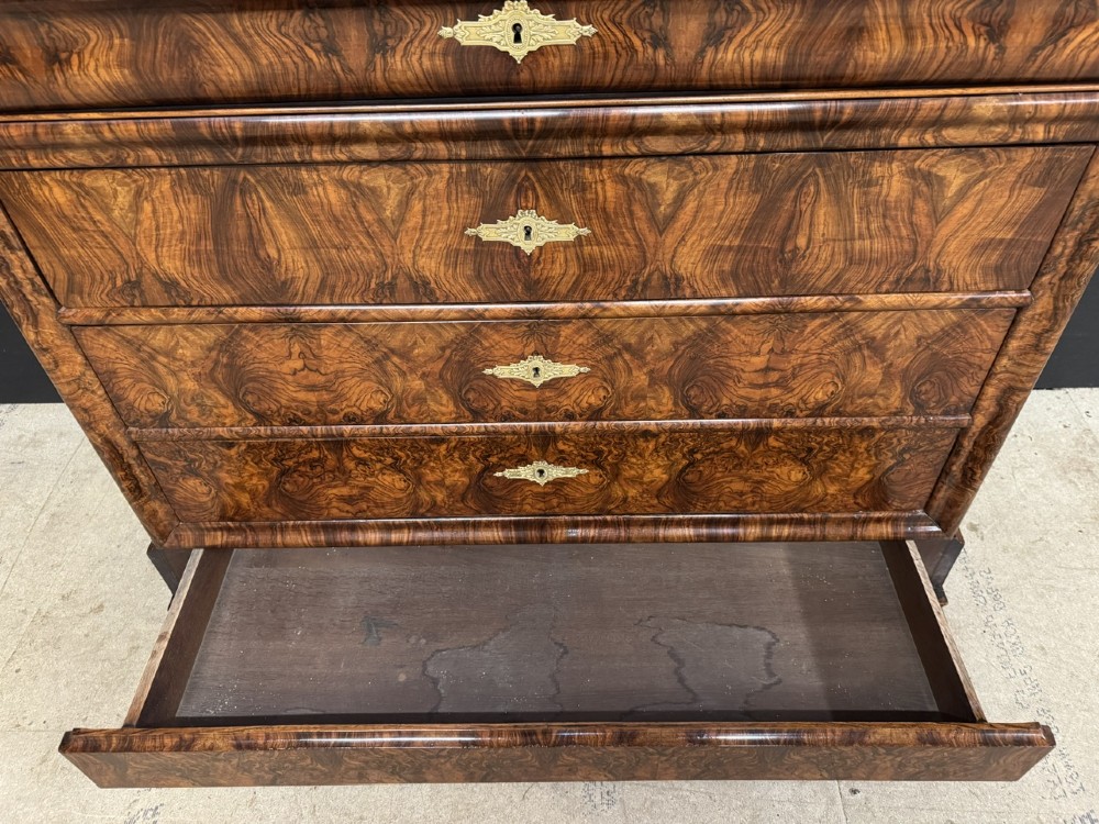 A 19th-century French Louis Philippe burr walnut commode featuring a grey marble top, four drawers, and ornate brass keyhole escutcheons. View XI