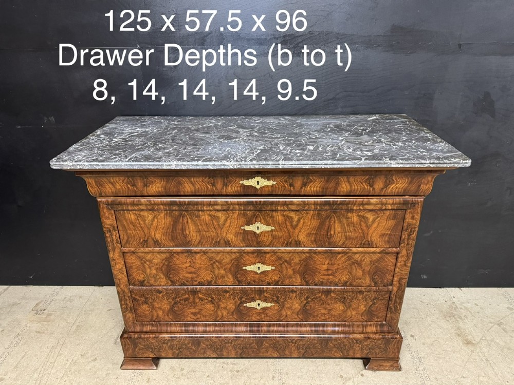 A 19th-century French Louis Philippe burr walnut commode featuring a grey marble top, four drawers, and ornate brass keyhole escutcheons. View XIV