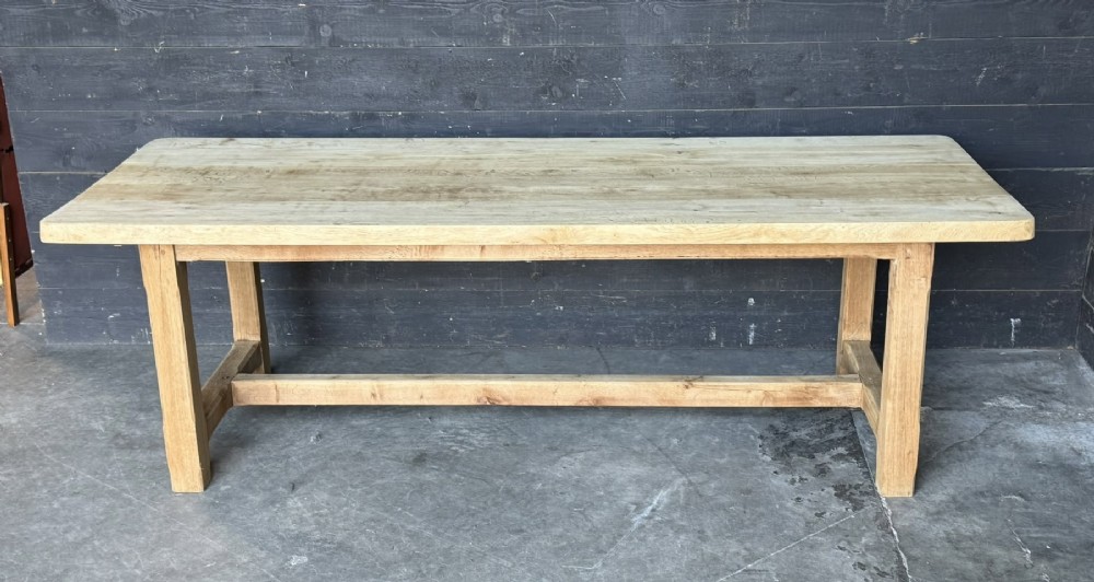 A large rectangular natural oak farmhouse dining table featuring a thick plank top, square legs, and an H-stretcher base. View II