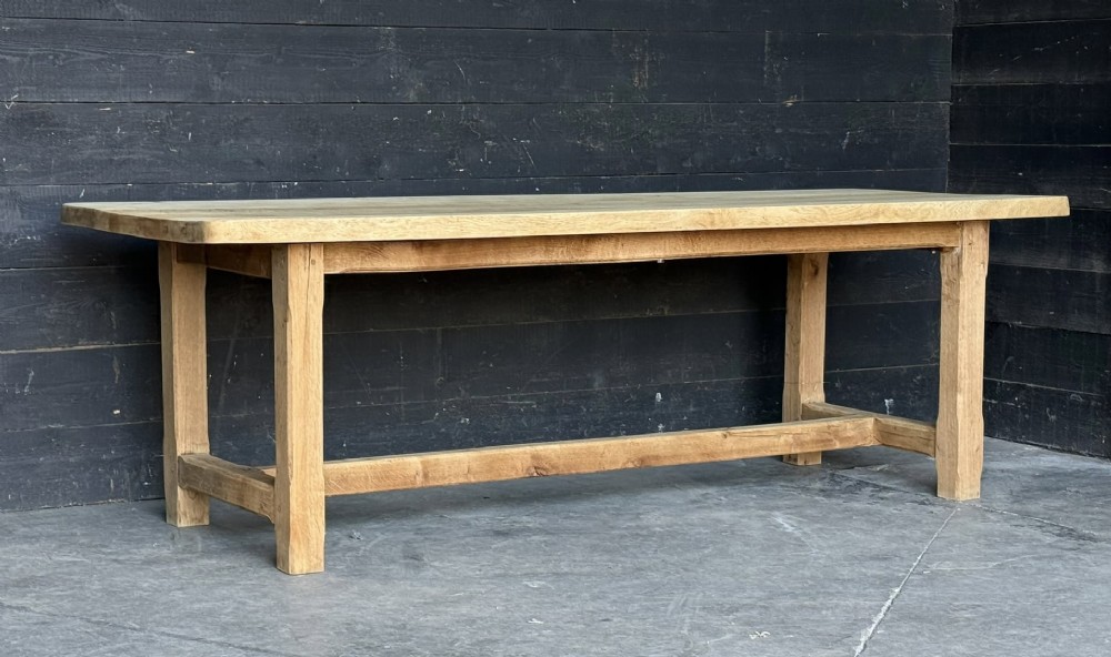 A large rectangular natural oak farmhouse dining table featuring a thick plank top, square legs, and an H-stretcher base. View V