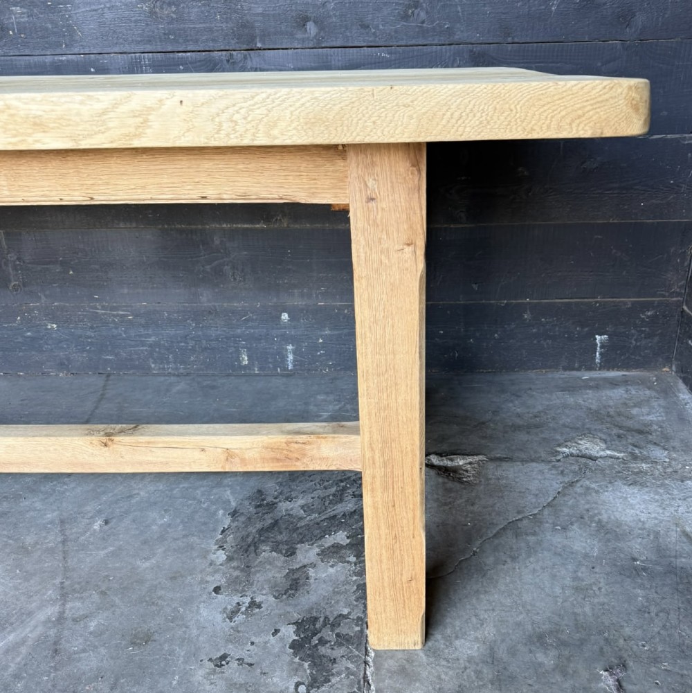 A large rectangular natural oak farmhouse dining table featuring a thick plank top, square legs, and an H-stretcher base. View VII