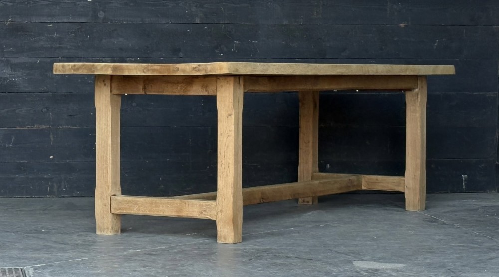 A large rectangular natural oak farmhouse dining table featuring a thick plank top, square legs, and an H-stretcher base. View VIII