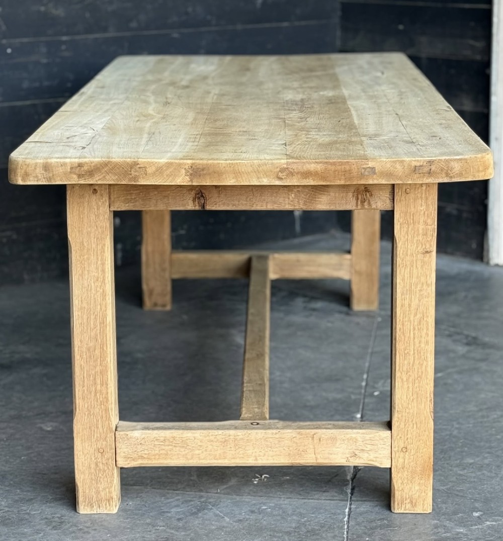 A large rectangular natural oak farmhouse dining table featuring a thick plank top, square legs, and an H-stretcher base. View XII