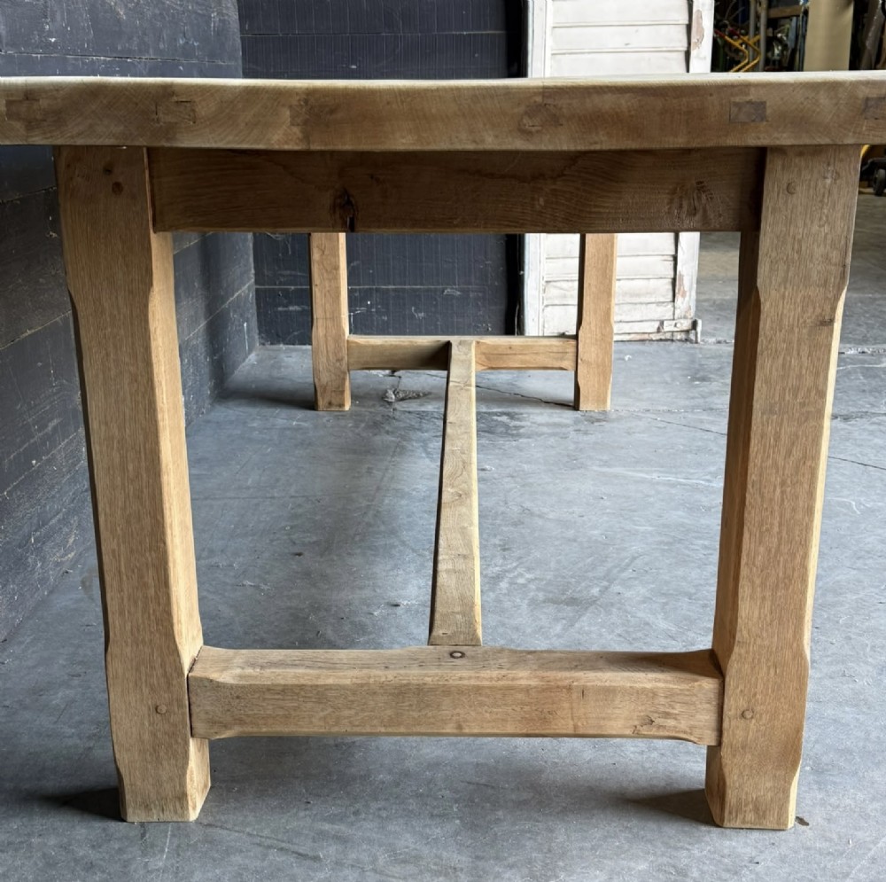 A large rectangular natural oak farmhouse dining table featuring a thick plank top, square legs, and an H-stretcher base. View XIII
