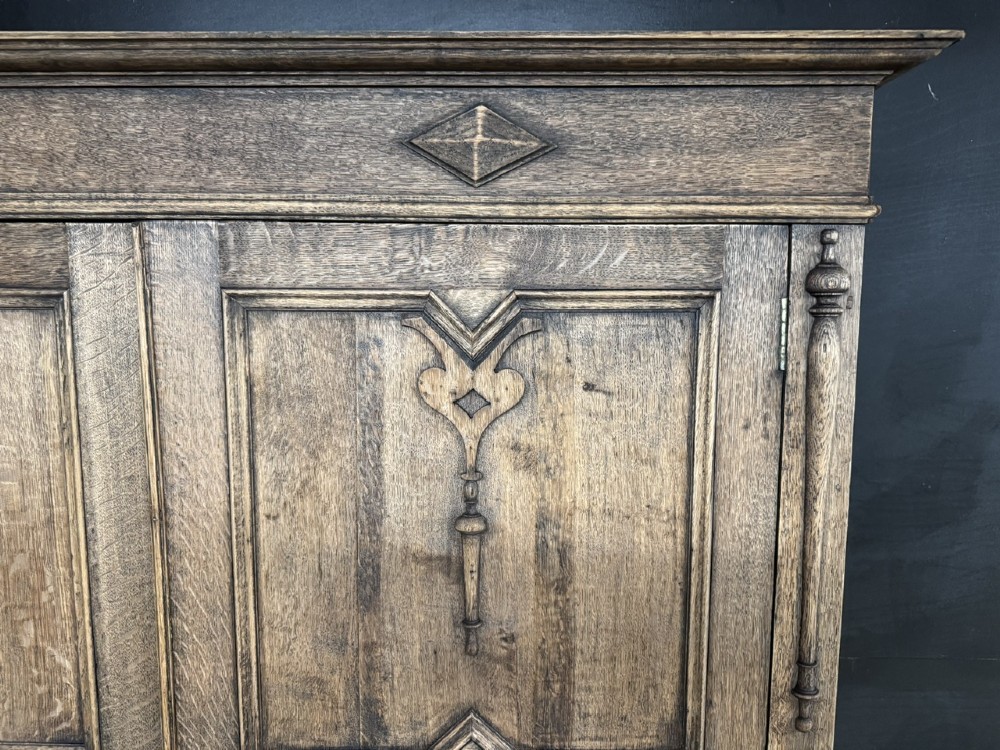A large carved oak hall bench featuring a high back with three cupboard doors, geometric diamond panelling, and a lift-top storage seat. View VI