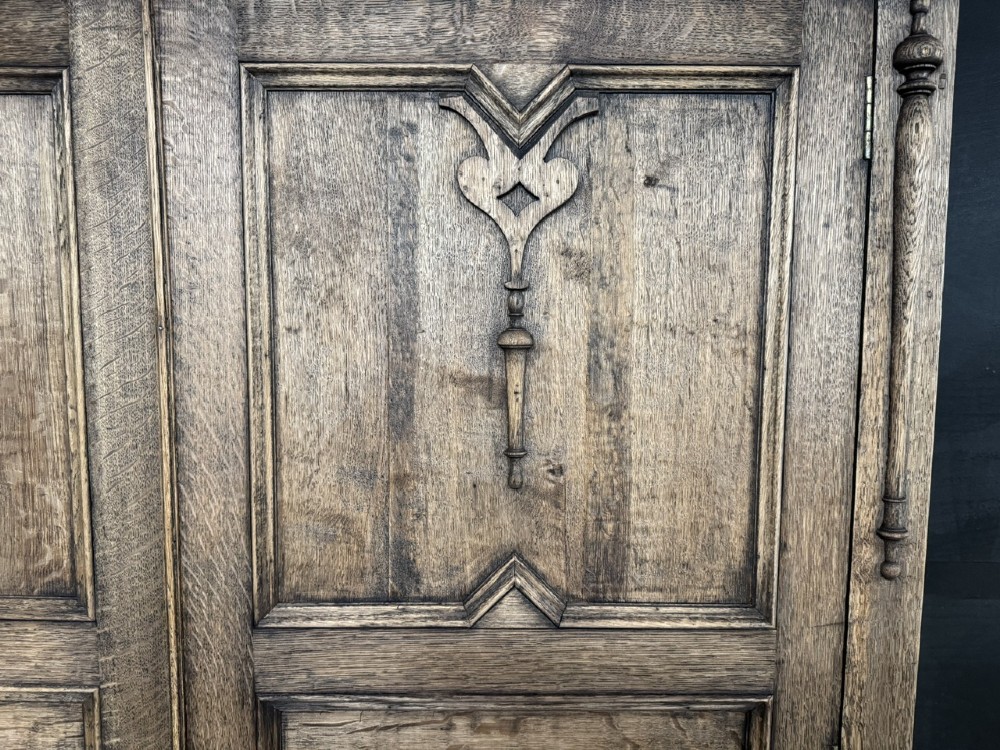 A large carved oak hall bench featuring a high back with three cupboard doors, geometric diamond panelling, and a lift-top storage seat. View VII