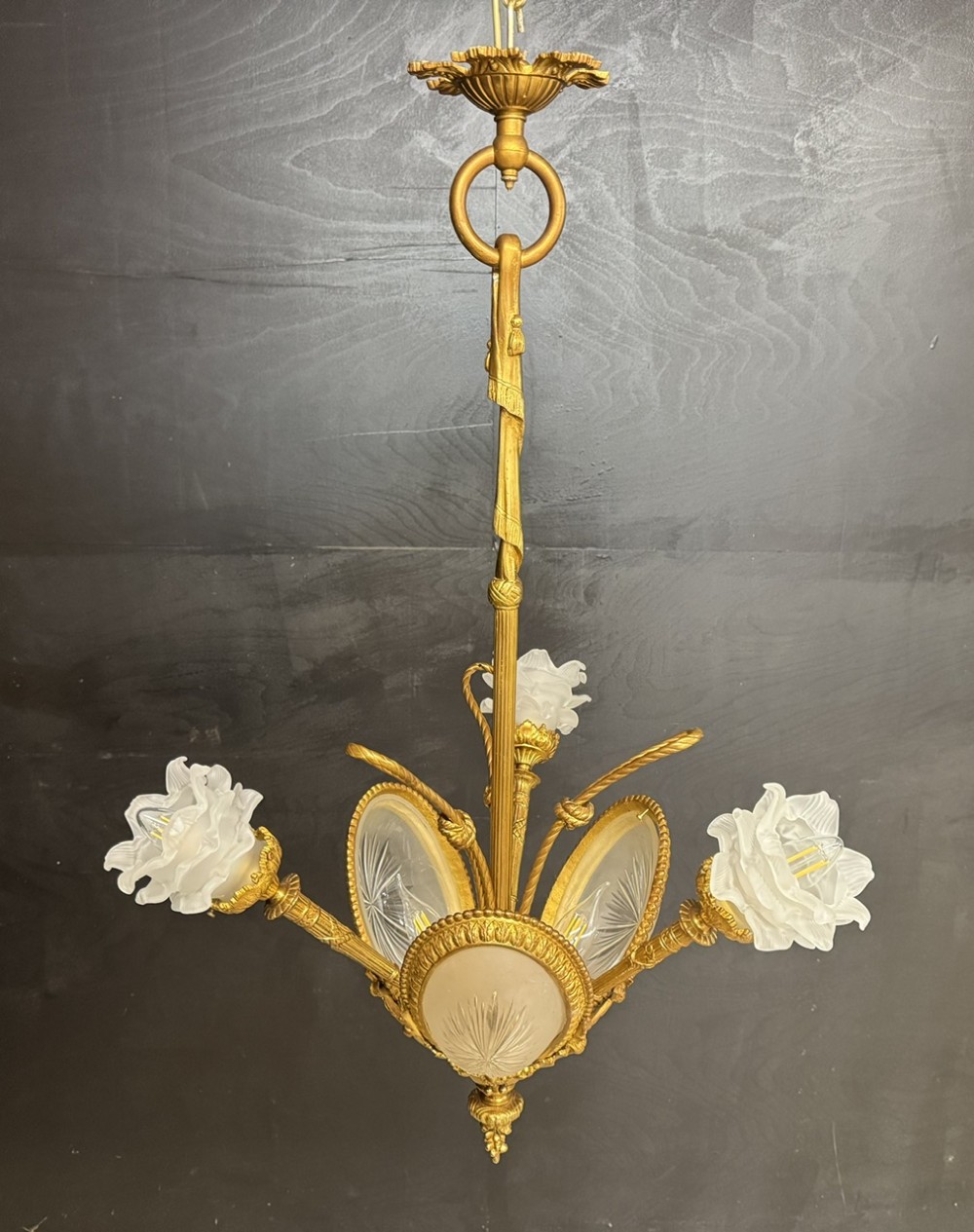 An ornate French gilt bronze chandelier featuring scroll arms, cut glass inserts, and ruffled white glass flower shades. View II