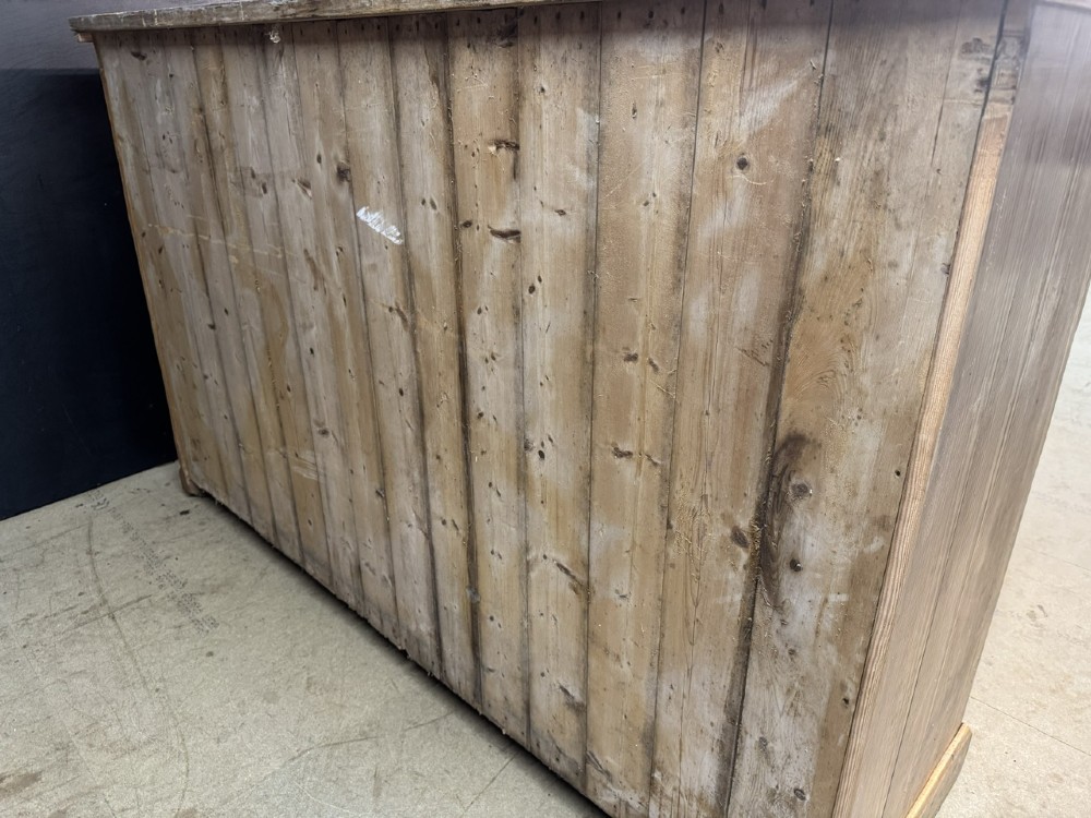A 19th-century natural pine housekeepers cupboard featuring four panelled doors with brass drop handles and a plinth base. View XIV