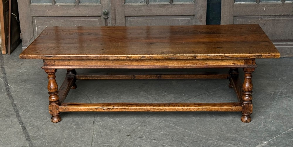 A low rectangular solid oak coffee table featuring a thick plank top, turned legs, and a low stretcher base. View II