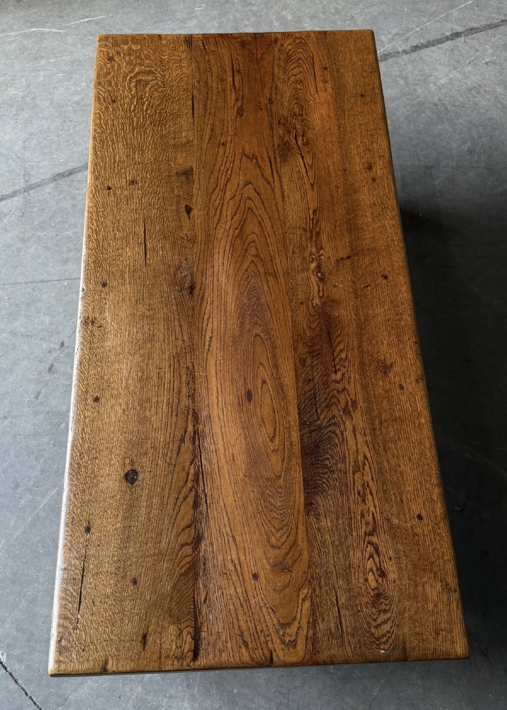 A low rectangular solid oak coffee table featuring a thick plank top, turned legs, and a low stretcher base. View III
