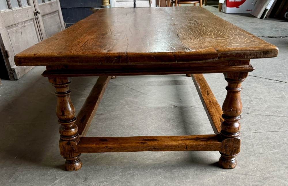 A low rectangular solid oak coffee table featuring a thick plank top, turned legs, and a low stretcher base. View IV
