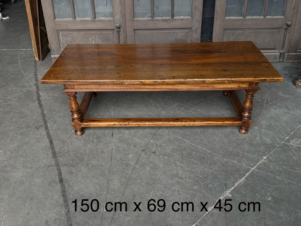 A low rectangular solid oak coffee table featuring a thick plank top, turned legs, and a low stretcher base. View VII