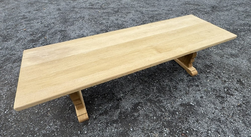 A three-metre-long natural oak trestle dining table featuring a solid plank top and a pegged central stretcher base. View XII