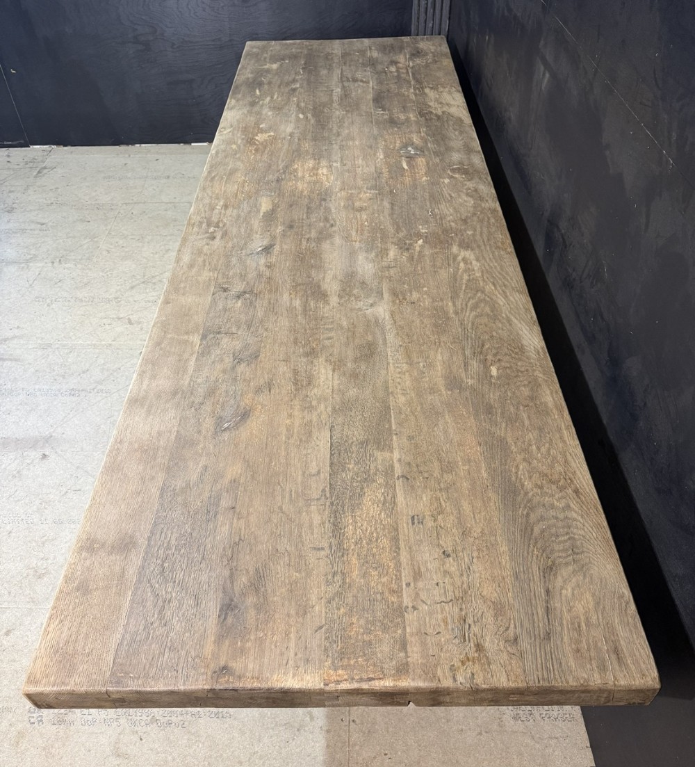 An extra long natural oak refectory dining table featuring a timber plank top supported by twin turned baluster trestle legs connected by a floor-level stretcher. View III