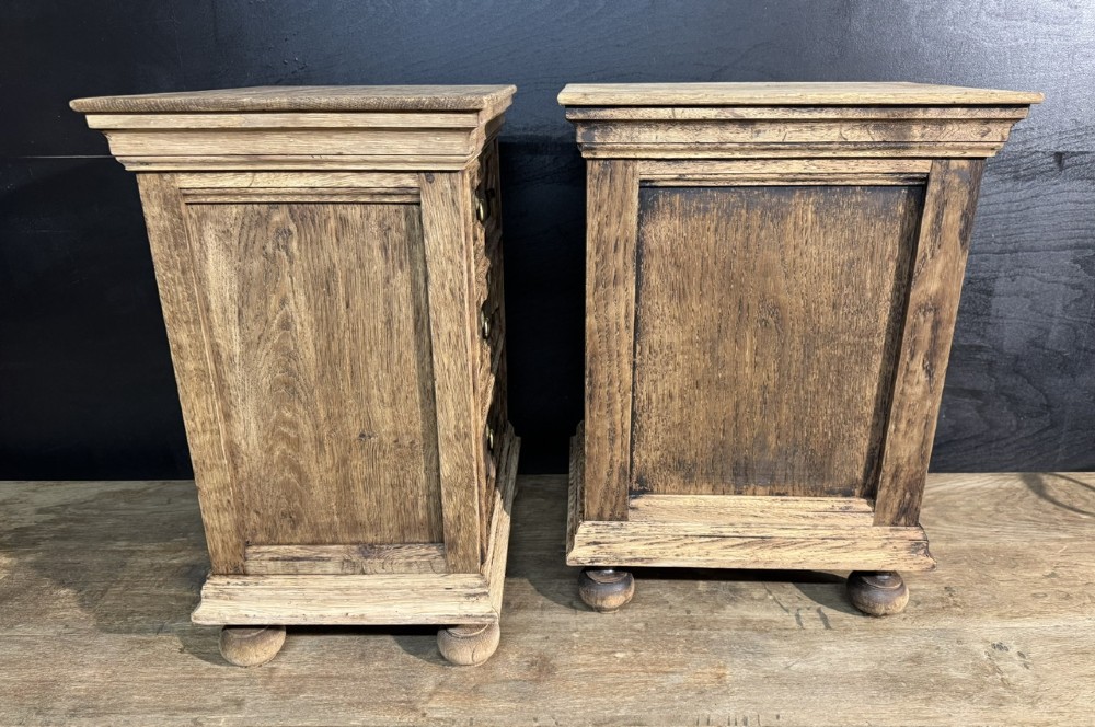 A pair of light oak three-drawer bedside chests with geometric carved drawer fronts, brass ring handles, and turned bun feet. View VI