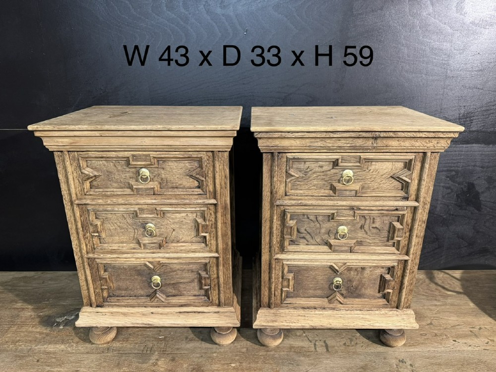 A pair of light oak three-drawer bedside chests with geometric carved drawer fronts, brass ring handles, and turned bun feet. View XII