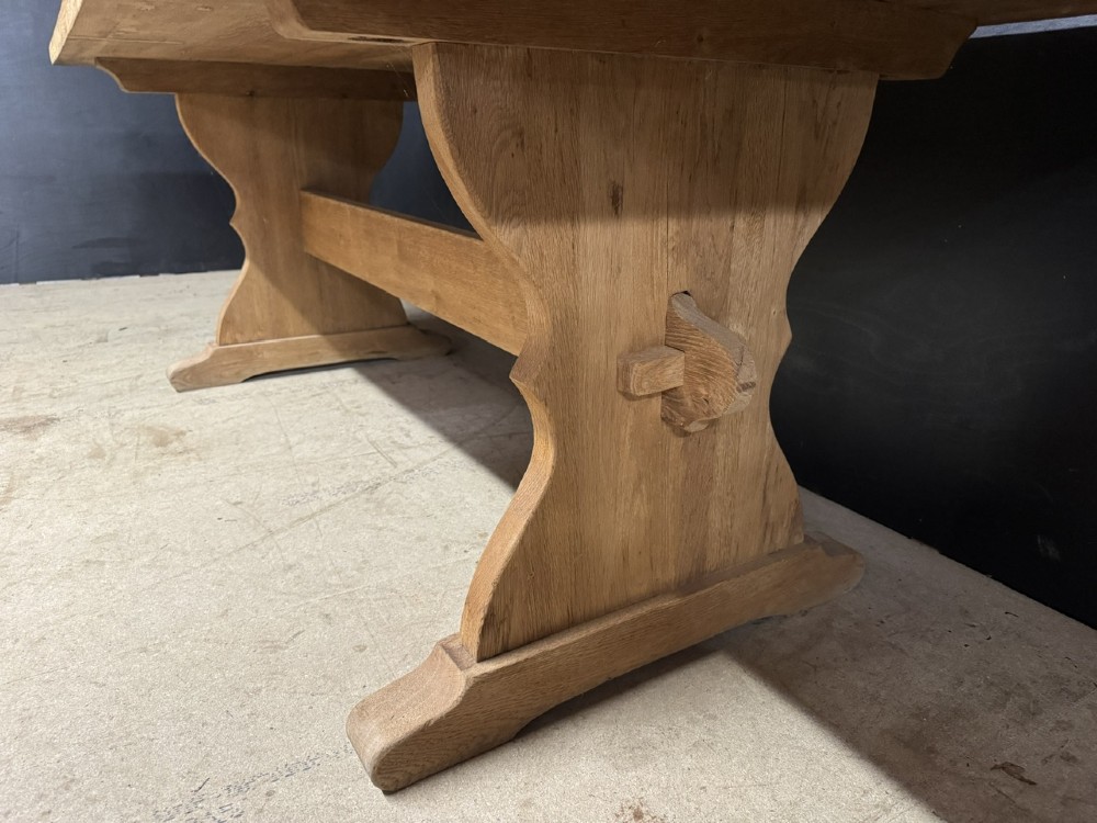 A large bleached oak farmhouse dining table featuring a thick plank top supported by a trestle base with a centre stretcher. View VII