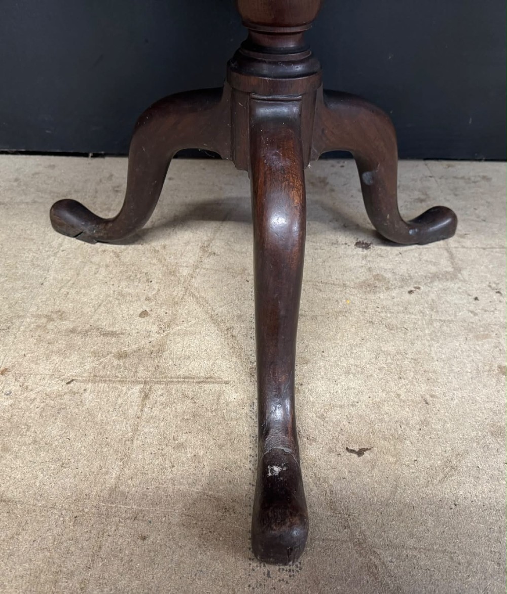 An antique circular oak tilt-top table featuring a three-plank top mounted on a turned pedestal column with three curved tripod legs. View IX