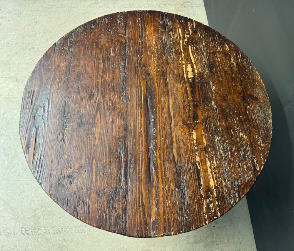 A circular French wine tasting table made of dark warm brown timber shown in a tilted position on a trestle base. View VII