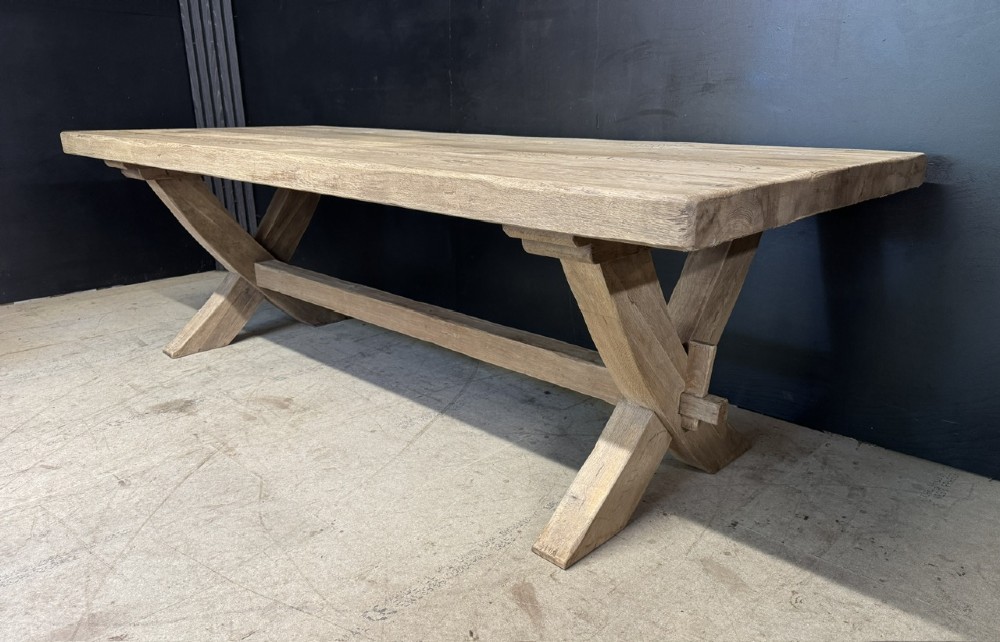 A large solid light oak dining table featuring an X-frame trestle base and a central key-joined stretcher. View III