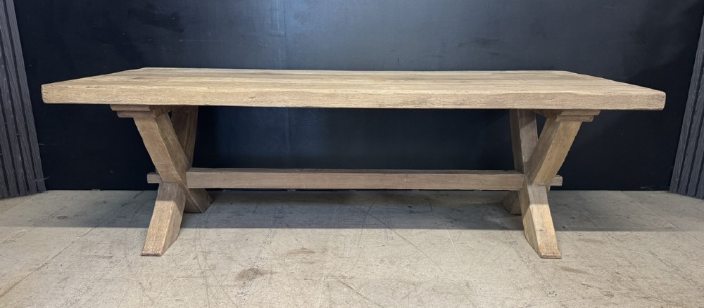 A large solid light oak dining table featuring an X-frame trestle base and a central key-joined stretcher. View VI
