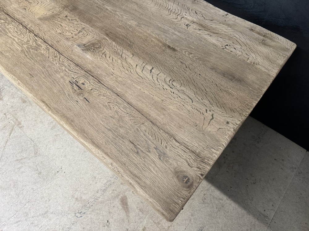 A large solid light oak dining table featuring an X-frame trestle base and a central key-joined stretcher. View VII