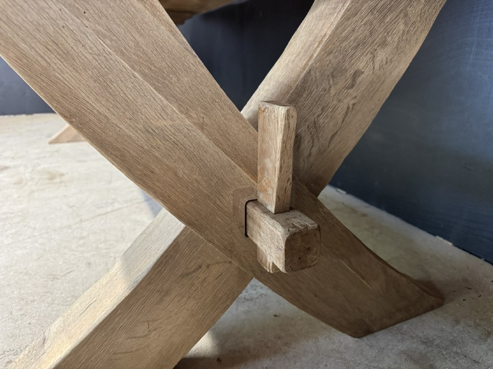 A large solid light oak dining table featuring an X-frame trestle base and a central key-joined stretcher. View XI