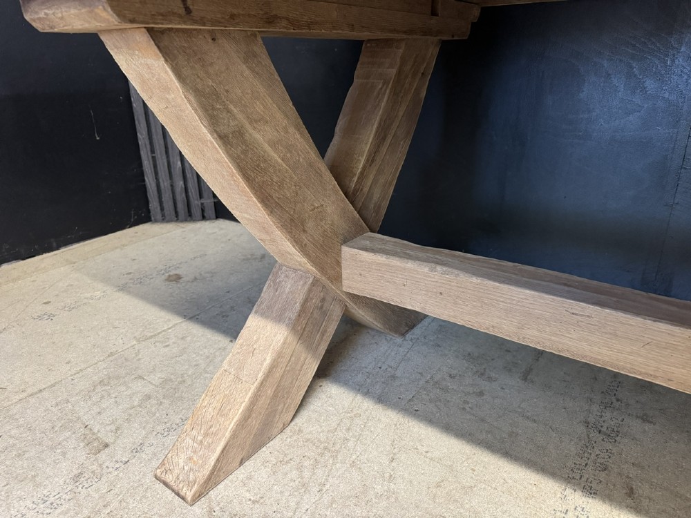 A large solid light oak dining table featuring an X-frame trestle base and a central key-joined stretcher. View XII