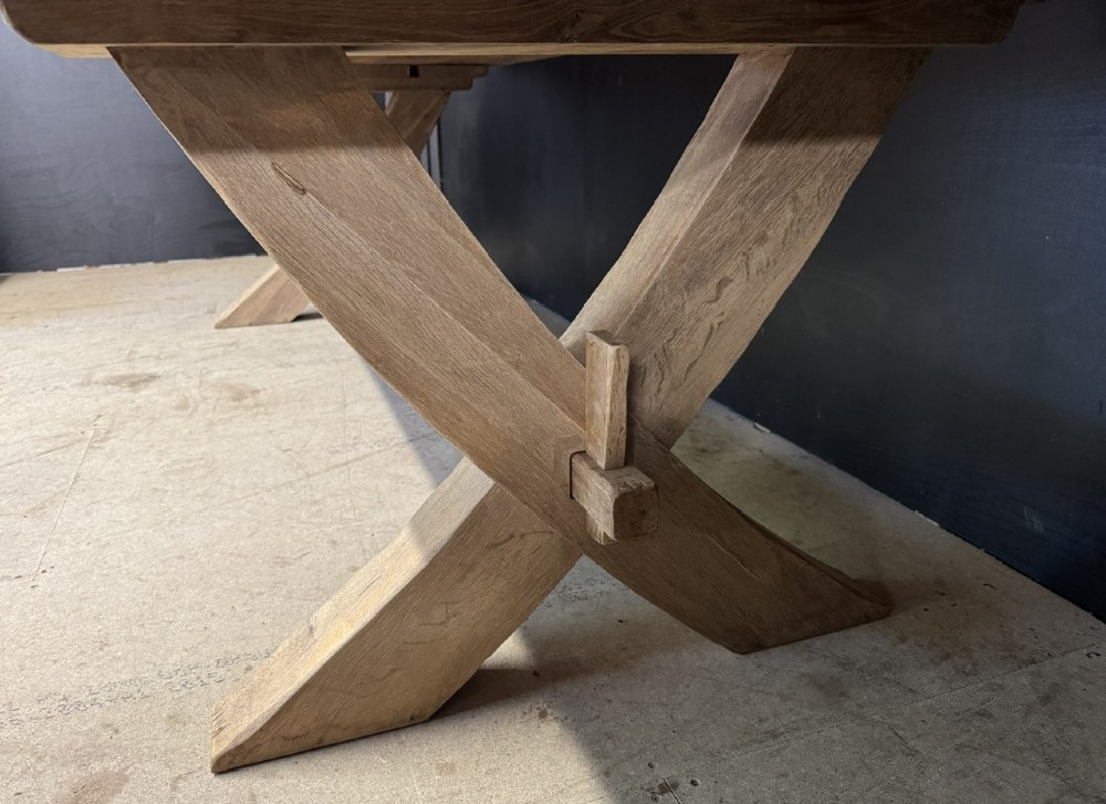 A large solid light oak dining table featuring an X-frame trestle base and a central key-joined stretcher. View XIII