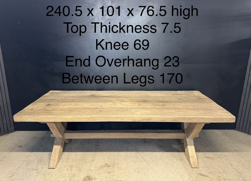 A large solid light oak dining table featuring an X-frame trestle base and a central key-joined stretcher. View XIV