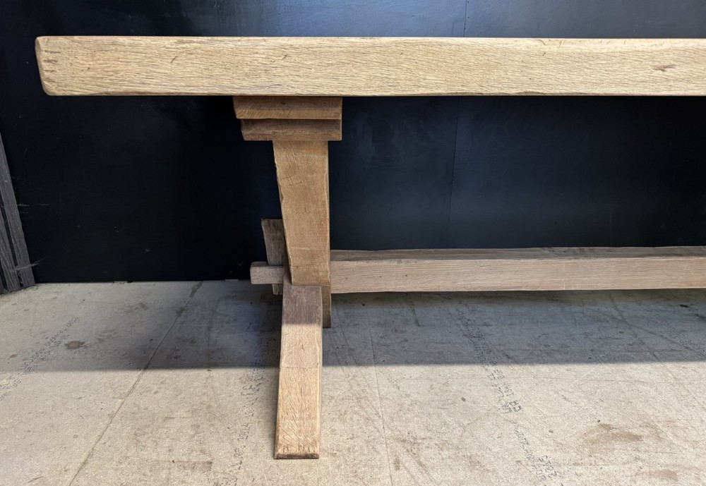 A large solid light oak dining table featuring an X-frame trestle base and a central key-joined stretcher. View XV