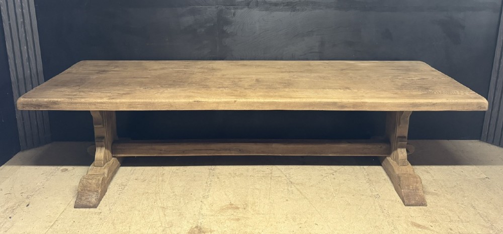 A long French oak trestle dining table featuring a thick wooden top, robust pedestal supports, and a central stretcher with pegged joints. View V
